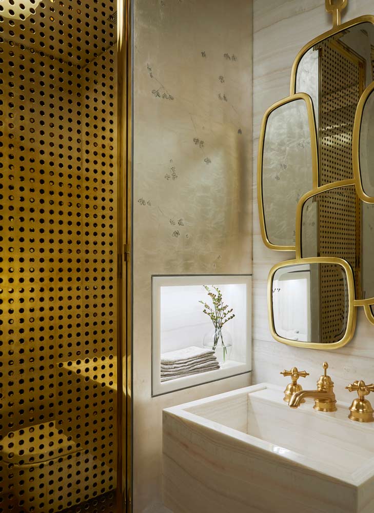 bathroom with hand painted wallpaper bronze cabinetry and gold plumbing fixtures